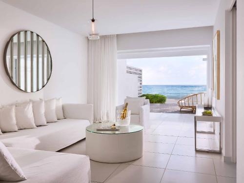 a living room with a white couch and a table at Grecotel LUXME White in Adelianos Kampos