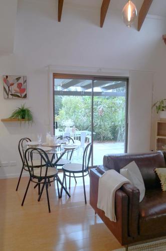 a living room with a couch and a table and chairs at Flaxton Eco-Chic Escape in Flaxton