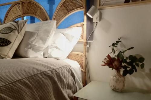 a bedroom with a bed and a vase with a plant at Flaxton Eco-Chic Escape in Flaxton