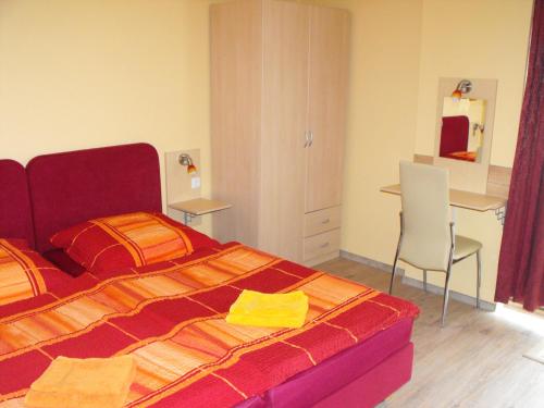 a bedroom with a bed and a desk and a chair at Pension Fürst Borwin in Markgrafenheide