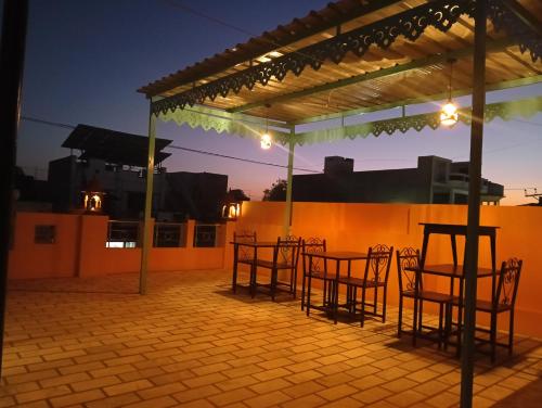 a patio with chairs and a pergola at night at Ardas Villa Bikaner - Heritage Luxury Boutique Stay in Bikaner