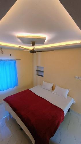 a bedroom with a large white bed with a red blanket at Alka guest house in Pushkar