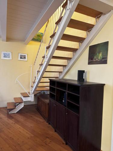 a living room with a staircase and a wooden cabinet at Agriturismo Vivace in Tolentino