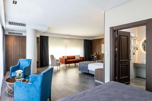 a hotel room with a bed and a living room at Ezkar Bathonea Art İstanbul Hotel in Avcılar