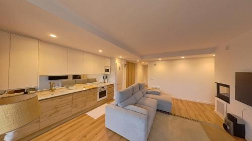 a living room with a couch and a kitchen at Hadar Deluxe - tucasaenlospirineos in Escarrilla
