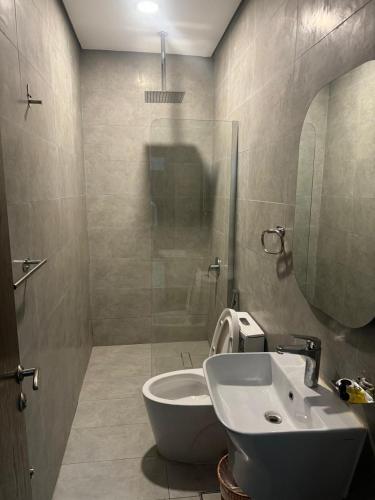 a bathroom with a toilet and a sink and a shower at Al Thanaa Alraqi Furnished Apartments in Jeddah