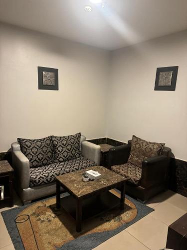 a living room with two couches and a coffee table at Al Thanaa Alraqi Furnished Apartments in Jeddah