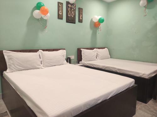 two beds in a room with balloons on the wall at Hotel Royal Inn in Salkhia