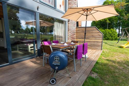 a wooden deck with a table and an umbrella at Ferien_HAUS AM AHORNECK _ THEA in Göhren-Lebbin