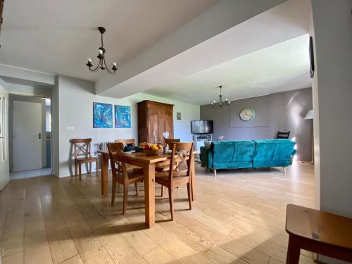 un salon avec une table et un canapé bleu dans l'établissement La Camuche, à Surrain