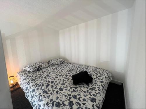 - un sac noir assis sur un lit dans une chambre dans l'établissement Studio cosy au centre-ville aux calmes, à Avignon