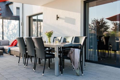a dining table and chairs on a patio at Luxus Ferien VILLA VIVALDI in Göhren-Lebbin