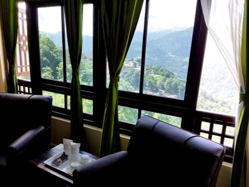 a room with two chairs and a table in front of a window at Hangsaha Regency in Gangtok