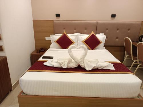 a bedroom with a bed with a white bow on it at Hotel Hebron Suites in Bengaluru