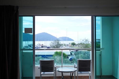 a room with a table and chairs and a large window at Okay Marina Lumut Homestay in Lumut