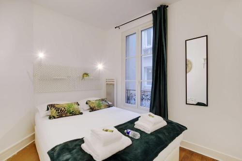 une chambre avec un lit blanc et une fenêtre dans l'établissement Magnificent apartment - 1BR 4P - Sacré-Cœur, à Paris