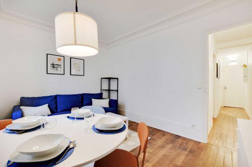 une salle à manger blanche avec une table et des chaises blanches dans l'établissement Magnificent apartment - 1BR 4P - Sacré-Cœur, à Paris