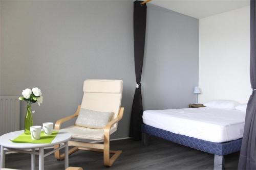 une chambre avec un lit, une chaise et une table dans l'établissement Appt Studio LA ROCHELLE LR240-402, à La Rochelle