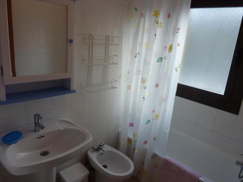 a bathroom with a sink and a toilet and a shower curtain at El Molino in Castejón de Sos