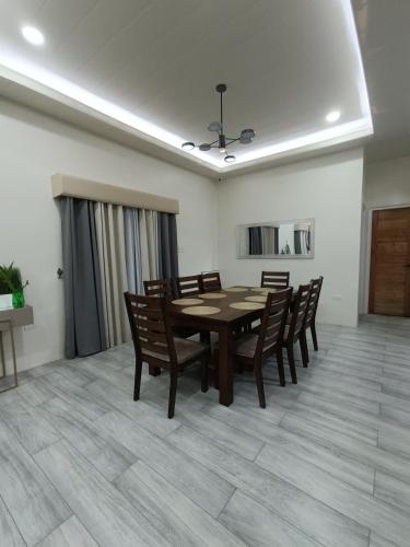 a dining room with a wooden table and chairs at La Bella Lipa in Lipa