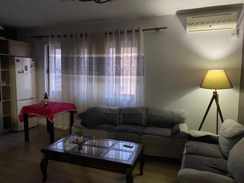 a living room with a couch and a table at Shkodra City Apartment in Shkodër