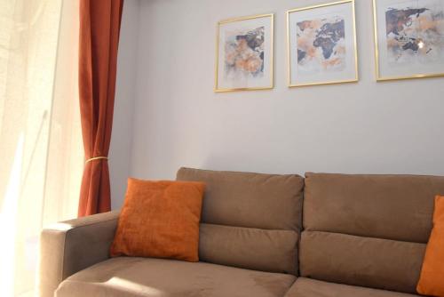 un divano in soggiorno con immagini appese al muro di 2 bedroom Flat close to Valletta & Sliema - Orion 1 a Msida