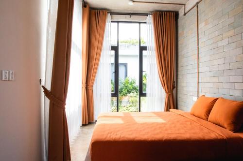 a bedroom with a bed and a large window at Takak Villas in Siem Reap