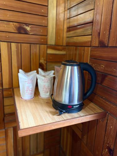 a tea kettle sitting on a wooden shelf at Aurave Inn in Kasol