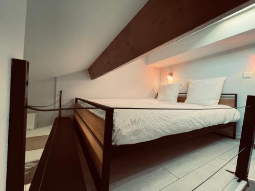 - une chambre avec un lit doté d'un cadre en bois dans l'établissement Duplex Élégant au Cœur de Nice, à Nice