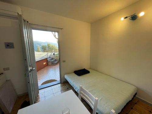 een kleine kamer met een bed en een glazen schuifdeur bij da Paolone in Deiva Marina