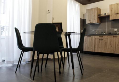 a glass table with black chairs in a kitchen at Porta Nuova Luxury Apartments in Turin