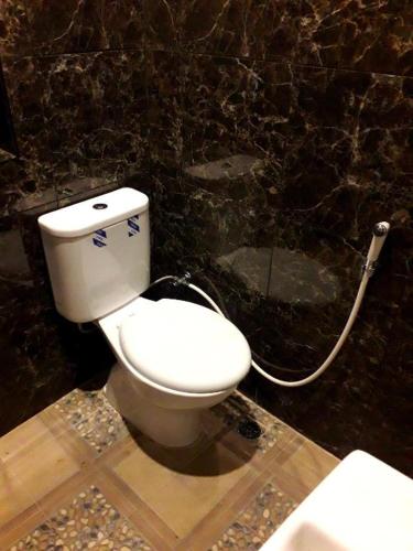 a bathroom with a toilet with a hose at Ahza syariah in Rantauprapat