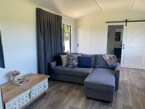 a living room with a couch and a coffee table at Relaxing Rural Retreat in Huntly