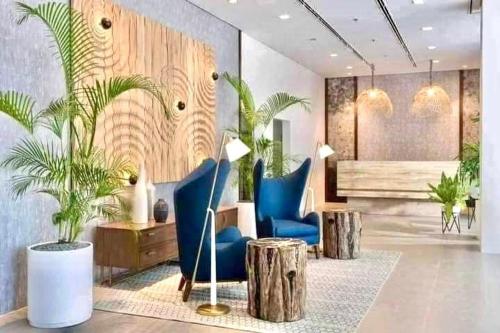 a lobby with blue chairs and palm trees at Hidden Gem at Cebu Business Park in Cebu City