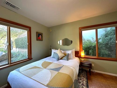 a bedroom with a bed and two large windows at Downtown Solvang l Most Desired Home l 2BR in Solvang