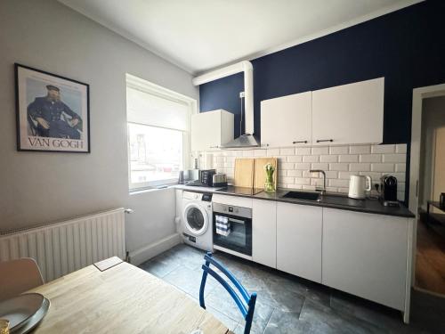 a kitchen with a sink and a washing machine at Huge apartment with Sauna and free parking in Duisburg