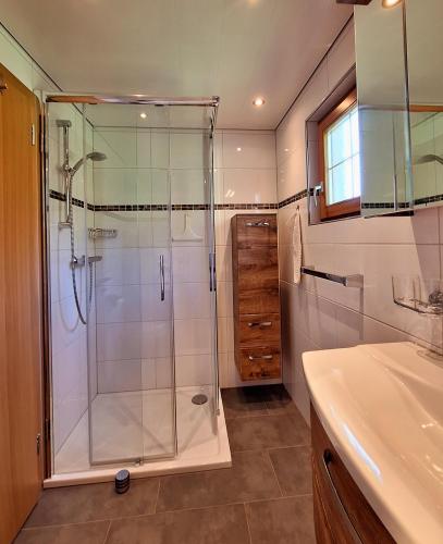 a bathroom with a shower and a sink at Ferienwohnung Angelina in Bartholomäberg