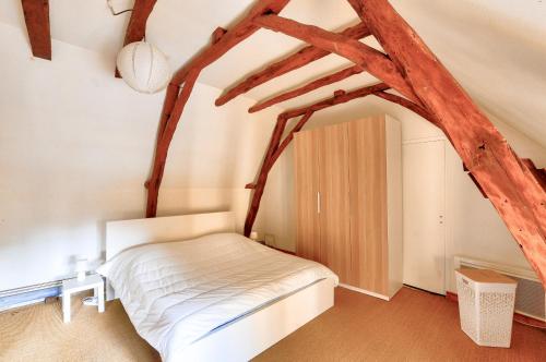 Schlafzimmer mit einem Bett in einem Zimmer mit Holzbalken in der Unterkunft Maison en pierre avec piscine et terrasse pour 6 in Montignac