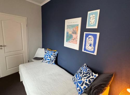 a bedroom with blue walls and a bed with pillows at Huge apartment with Sauna and free parking in Duisburg