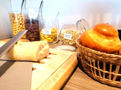 a table with a basket of bread and other foods at Kyriad Toulouse Sud - Roques in Roques Sur Garonne