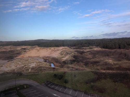 arial view of a mountain with a river and a road at La Broceliande in Neufchâtel-Hardelot