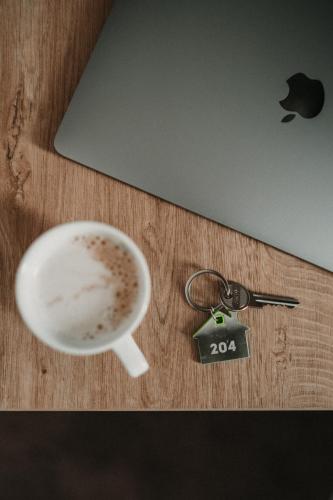 a table with a cup of coffee and a keys at ADEO HOTEL Sport & SPA in Ruse