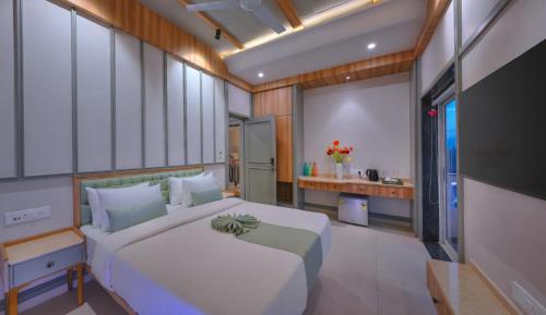a bedroom with a large white bed and a television at Vega Suites with Private Indoor Pool in Colva