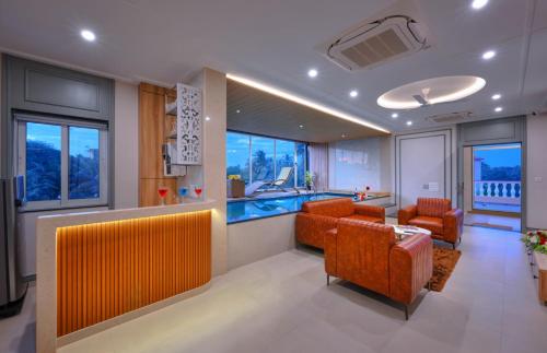 a lobby with orange chairs and a swimming pool at Vega Suites with Private Indoor Pool in Colva