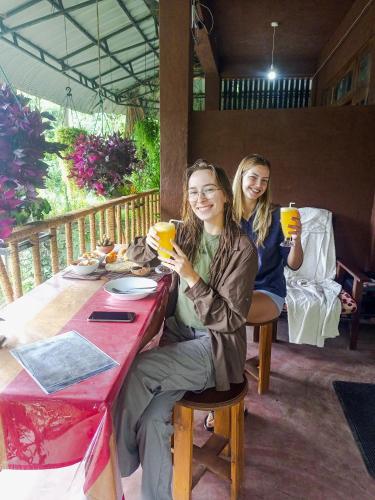 two women sitting at a table drinking orange juice at Creek Downhills in Ella
