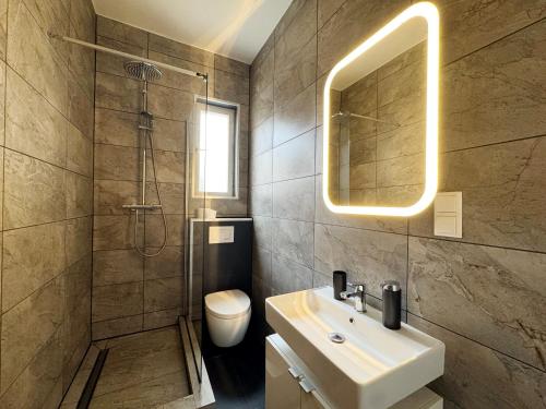 a bathroom with a sink and a shower and a toilet at Huge apartment with Sauna and free parking in Duisburg