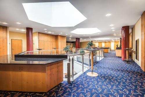 a lobby of a hotel with tables and counters at Congress Hotel Chemnitz in Chemnitz