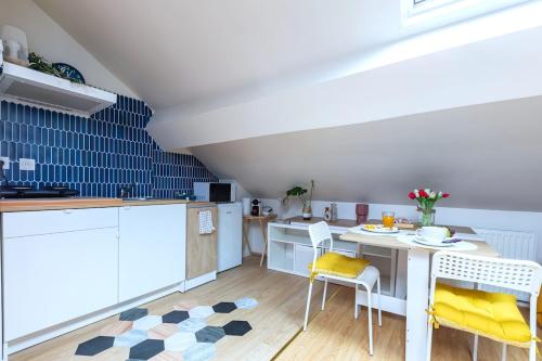 une cuisine avec une table et des chaises dans une pièce dans l'établissement Le Nid Chromatique, Hyper Centre Palaiseau, à Palaiseau