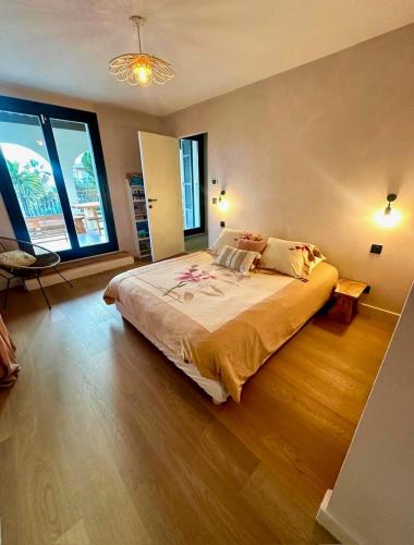 une chambre avec un grand lit et une grande fenêtre dans l'établissement La belle Villa de J et J, à Nice