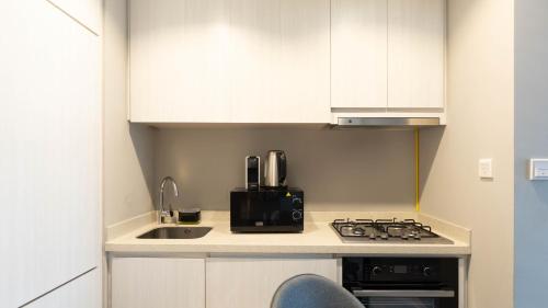 a small kitchen with a sink and a stove at Keyrock - Zada Tower, Business Bay Lake-View Apartment in Dubai